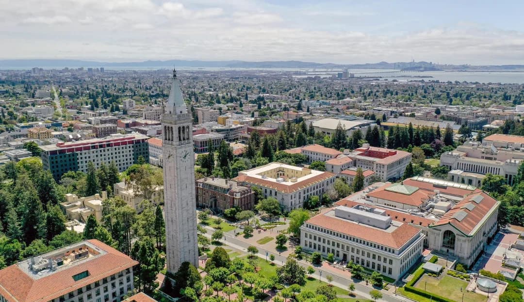 Aerial view of the UC Berkeley campus and Sather Tower with the San Francisco Bay behind it