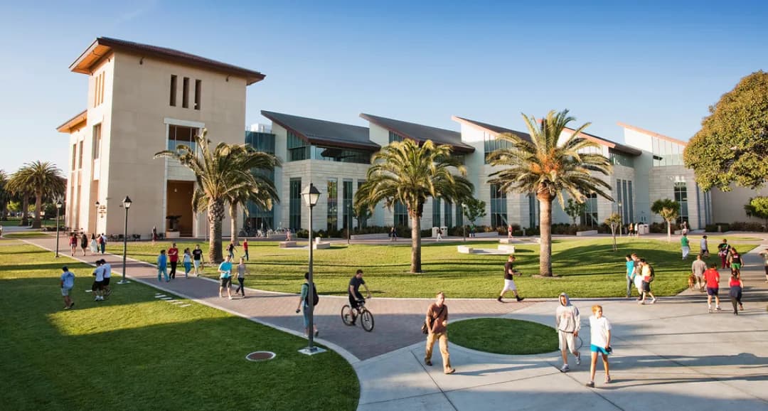 Students walking across the lawn at Santa Monica College among palm trees