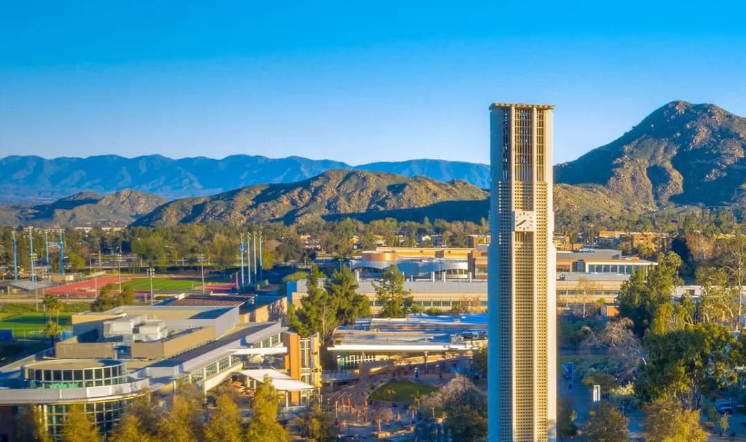 UC Riverside bell tower with mountains behind campus